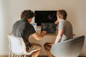 Developers chatting around a laptop